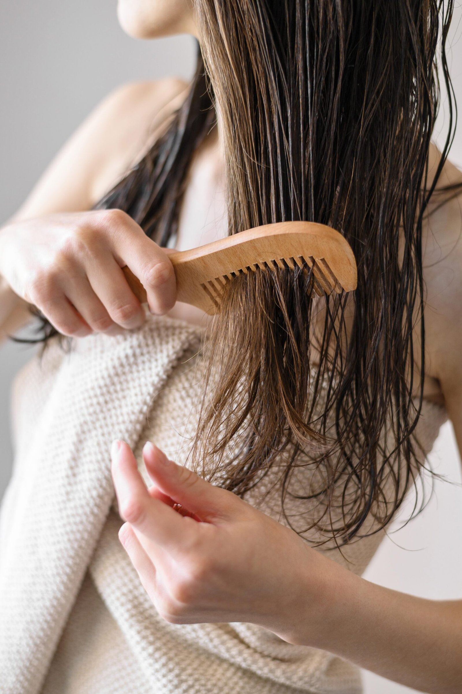 close up woman combing hair 1 scaled